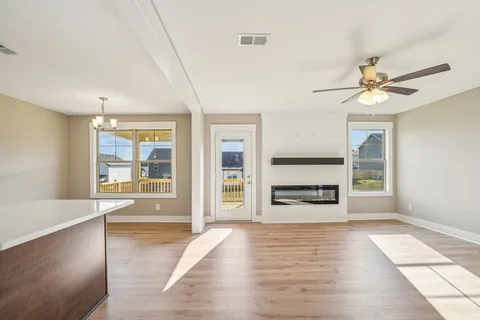 a view of an empty room with a fireplace and a window