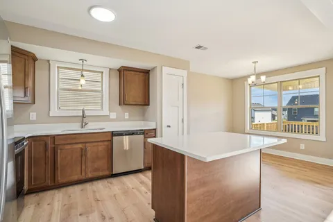 a kitchen with stainless steel appliances granite countertop a refrigerator a stove and a sink