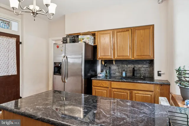 a kitchen with stainless steel appliances granite countertop a refrigerator a stove and a sink