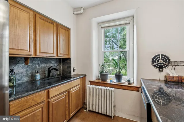 a kitchen with stainless steel appliances granite countertop a sink a stove and a window