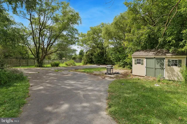 a view of a house with backyard and trees