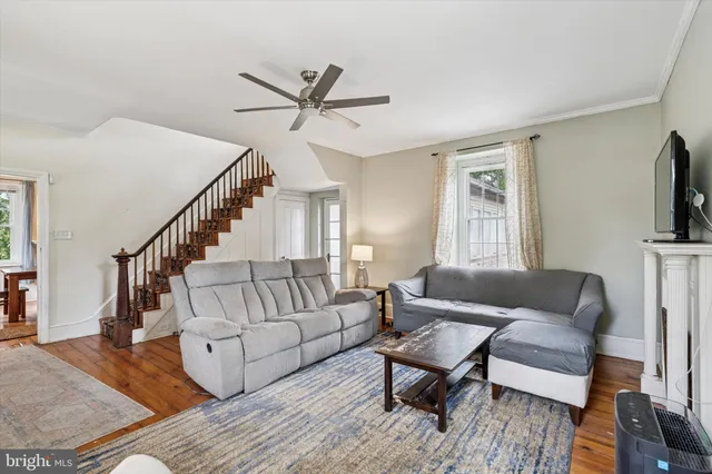 a living room with furniture a flat screen tv and a window
