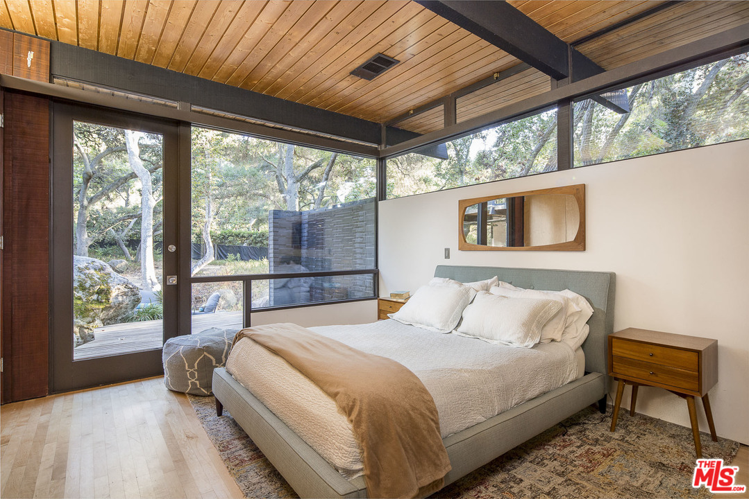 616 Cold Canyon Road Calabasas, CA 91302 - Photo 15 of 51 a bedroom with a bed and a large window