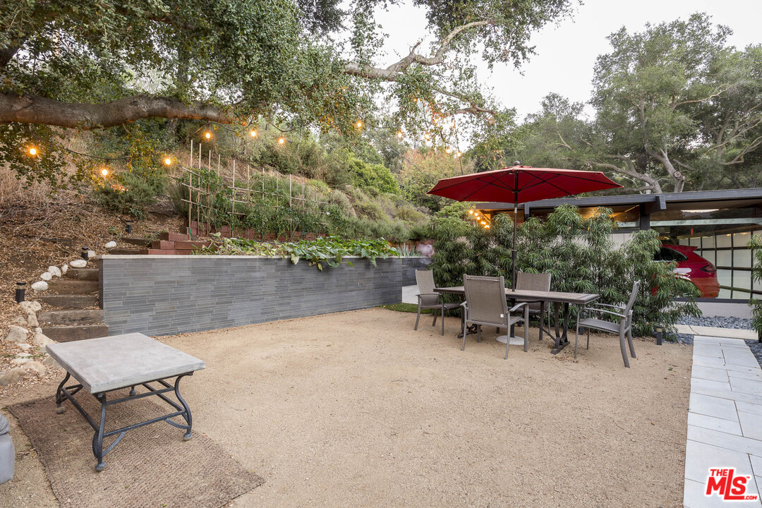 616 Cold Canyon Road Calabasas, CA 91302 - Photo 39 of 51 an outdoor sitting area with chairs and umbrella