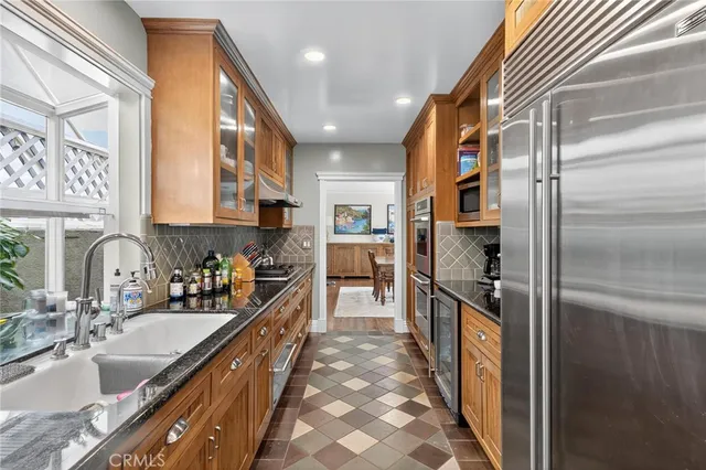 a kitchen with stainless steel appliances granite countertop a sink and a refrigerator