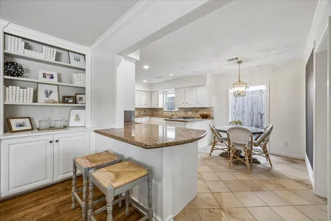 a kitchen with a dining table chairs and refrigerator