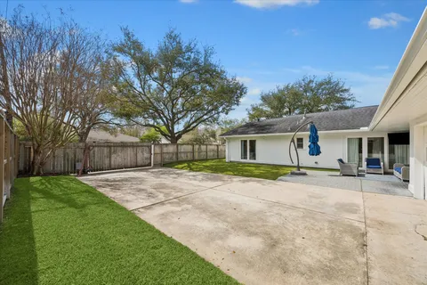 a view of a house with a yard and large trees