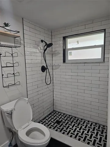 a bathroom with a toilet and a shower