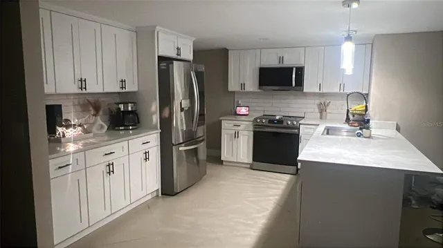 a kitchen with stainless steel appliances granite countertop a refrigerator stove a sink and dishwasher