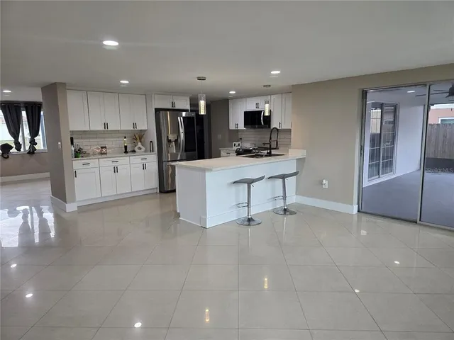 a kitchen with stainless steel appliances a refrigerator sink and cabinets