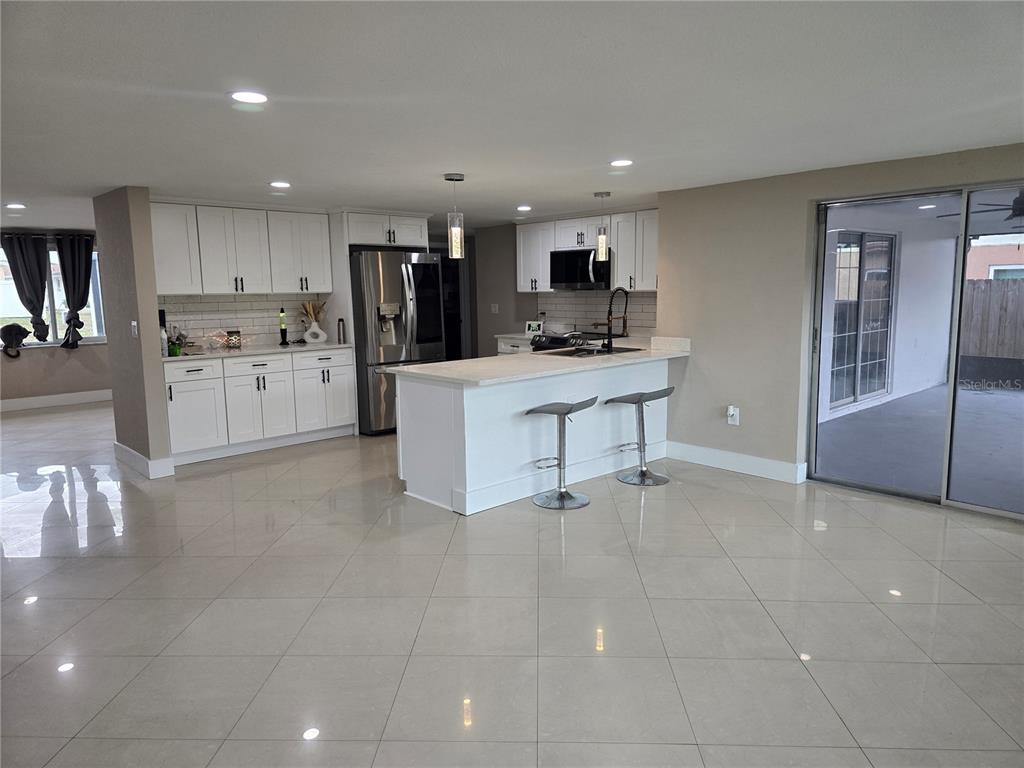 5813 Chapman Drive New Port Richey, FL 34652 - Photo 17 of 33 a kitchen with stainless steel appliances a refrigerator sink and cabinets