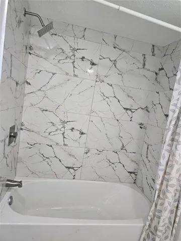 a bathroom with a bathtub and shower