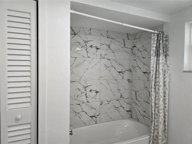 a bathroom with a bathtub and shower