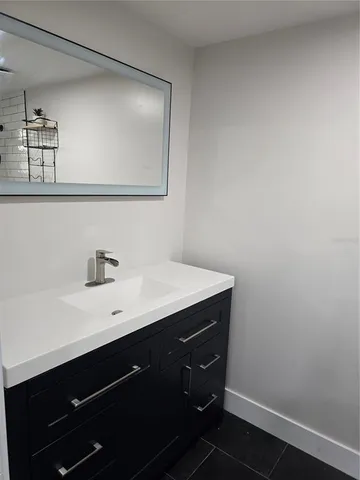 a bathroom with a sink vanity and mirror