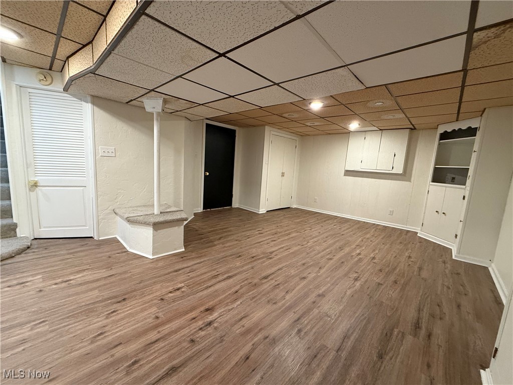 522 North 3rd Street Toronto, OH 43964 - Photo 37 of 47 Finished below grade area featuring wood finished floors, a paneled ceiling, and stairs
