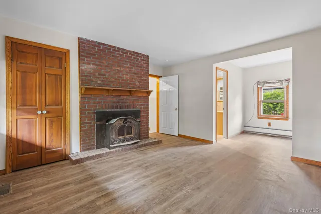 wooden floor fireplace and windows in an empty room