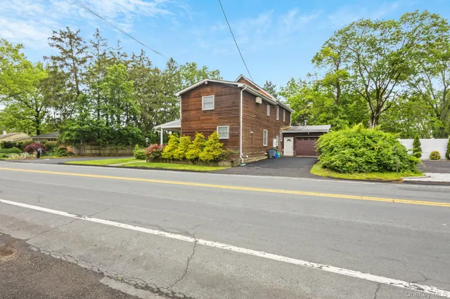 a front view of a house with a yard and potted plants