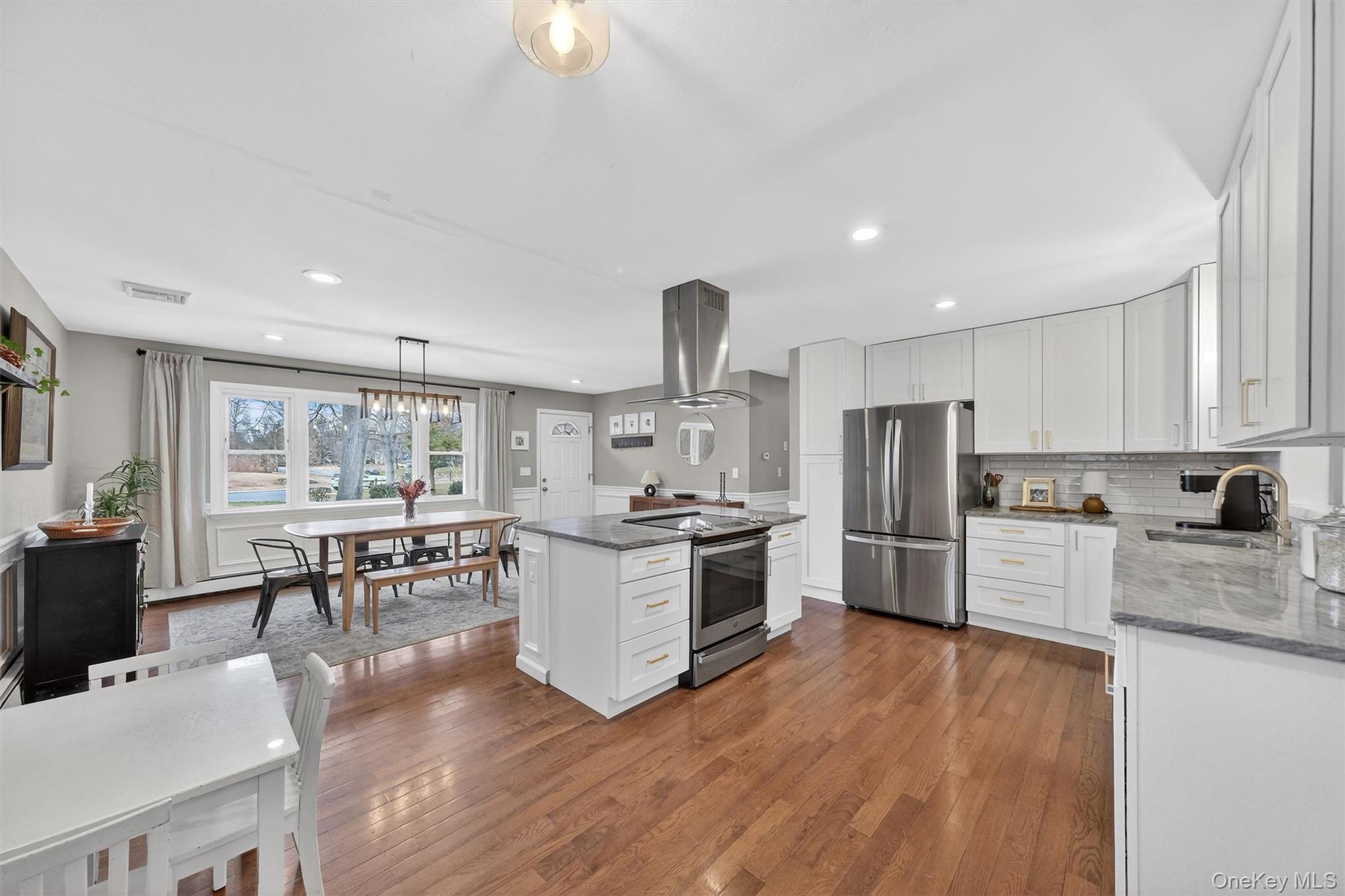 21 Russo Road Hopewell Junction, NY 12533 - Photo 12 of 41 a kitchen with granite countertop a stove top oven a sink dishwasher a dining table and chairs with wooden floor
