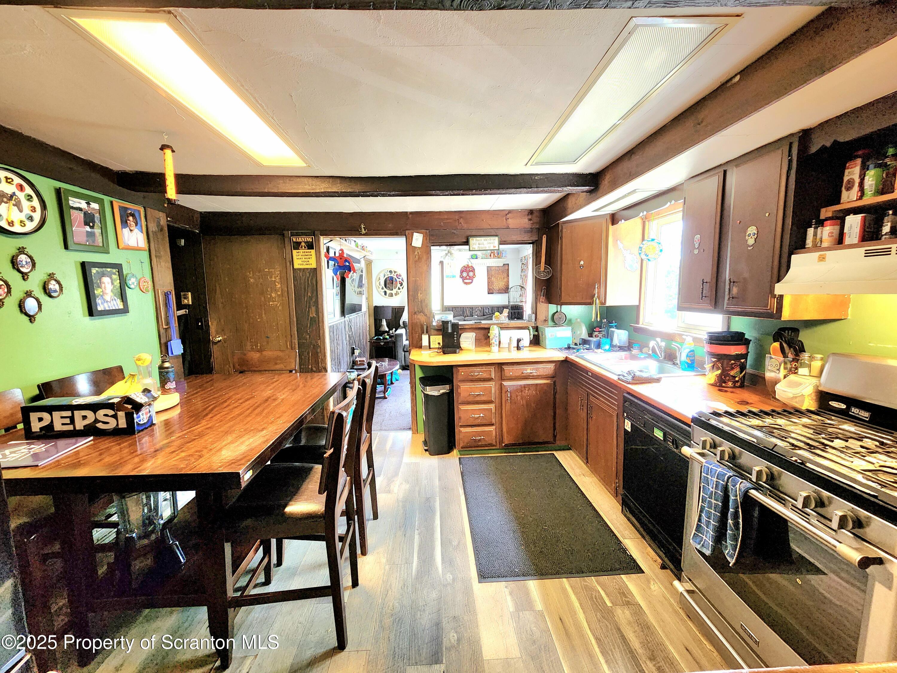365 Carpenter Road Factoryville, PA 18419 - Photo 3 of 30 a kitchen with stainless steel appliances granite countertop a stove top oven a sink a dining table and chairs
