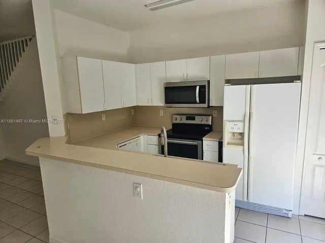 a kitchen with appliances a microwave and cabinets