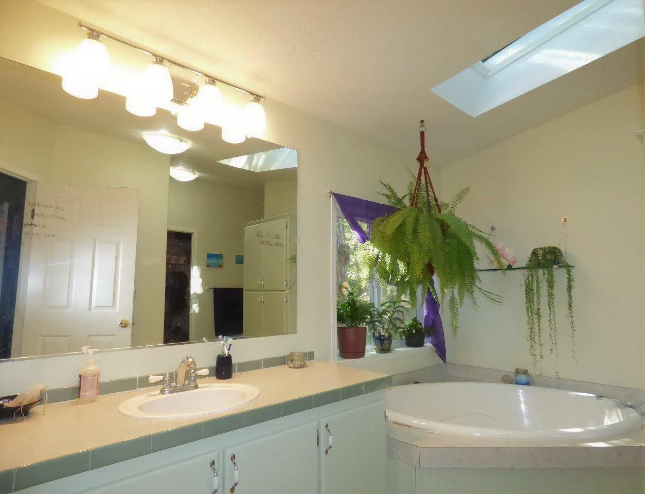 6520 Tunnel Loop Road Grants Pass, OR 97526 - Photo 23 of 69 a bathroom with a sink a large mirror and a shower