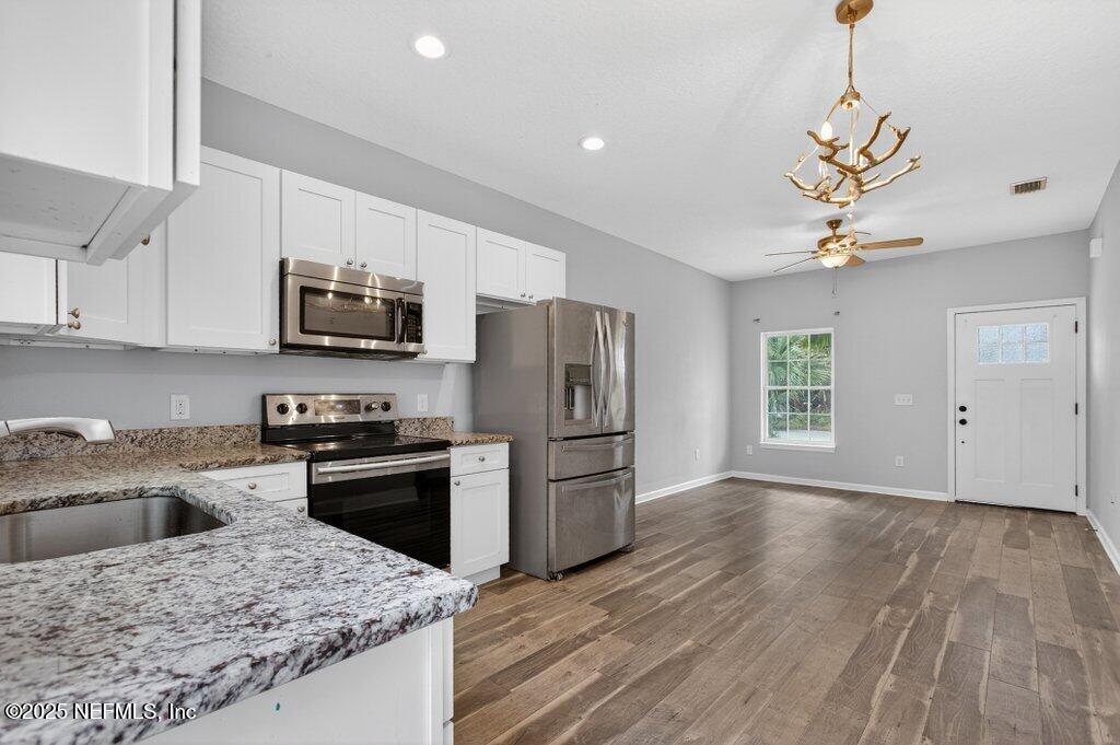 932 Puryear Street St. Augustine, FL 32084 - Photo 12 of 29 a kitchen with a sink a microwave a stove and refrigerator