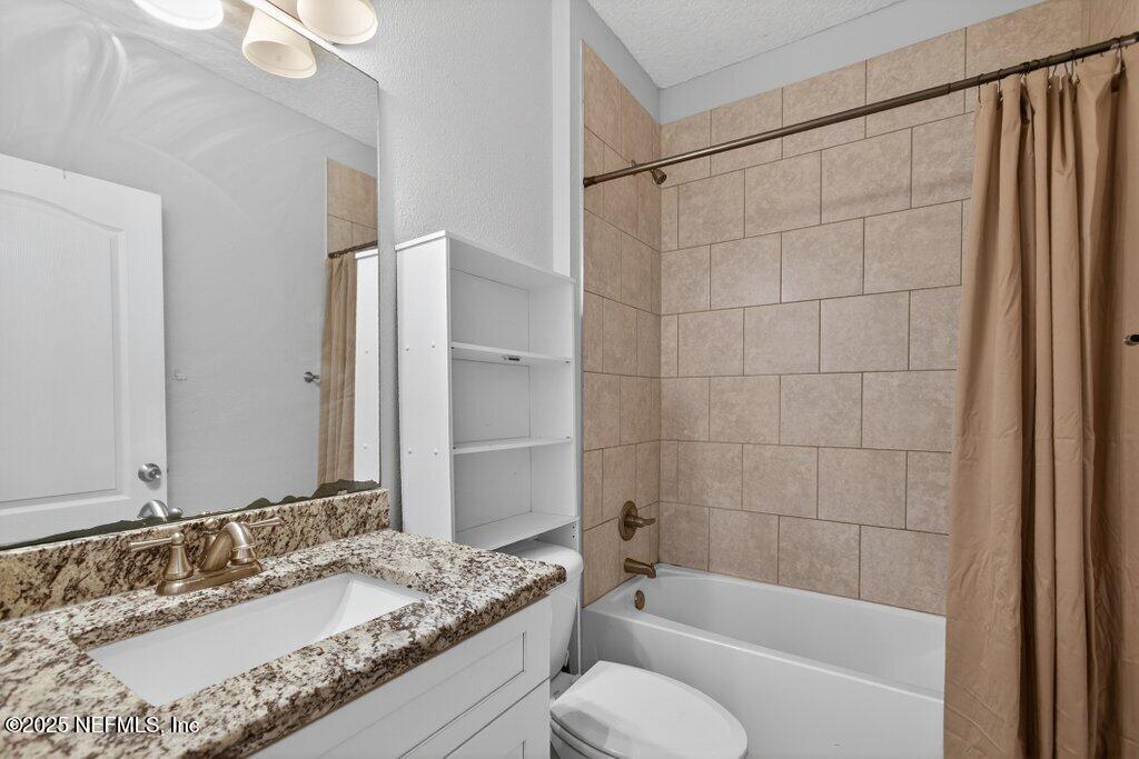 932 Puryear Street St. Augustine, FL 32084 - Photo 17 of 29 a bathroom with a granite countertop sink and a mirror a bathtub
