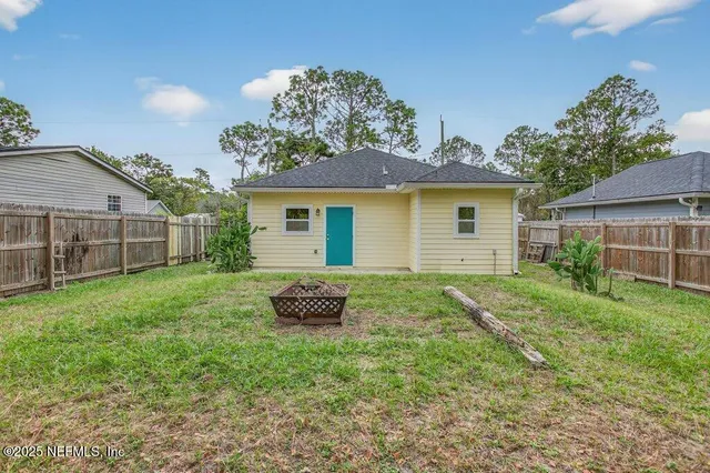 a backyard of a house with table and chairs