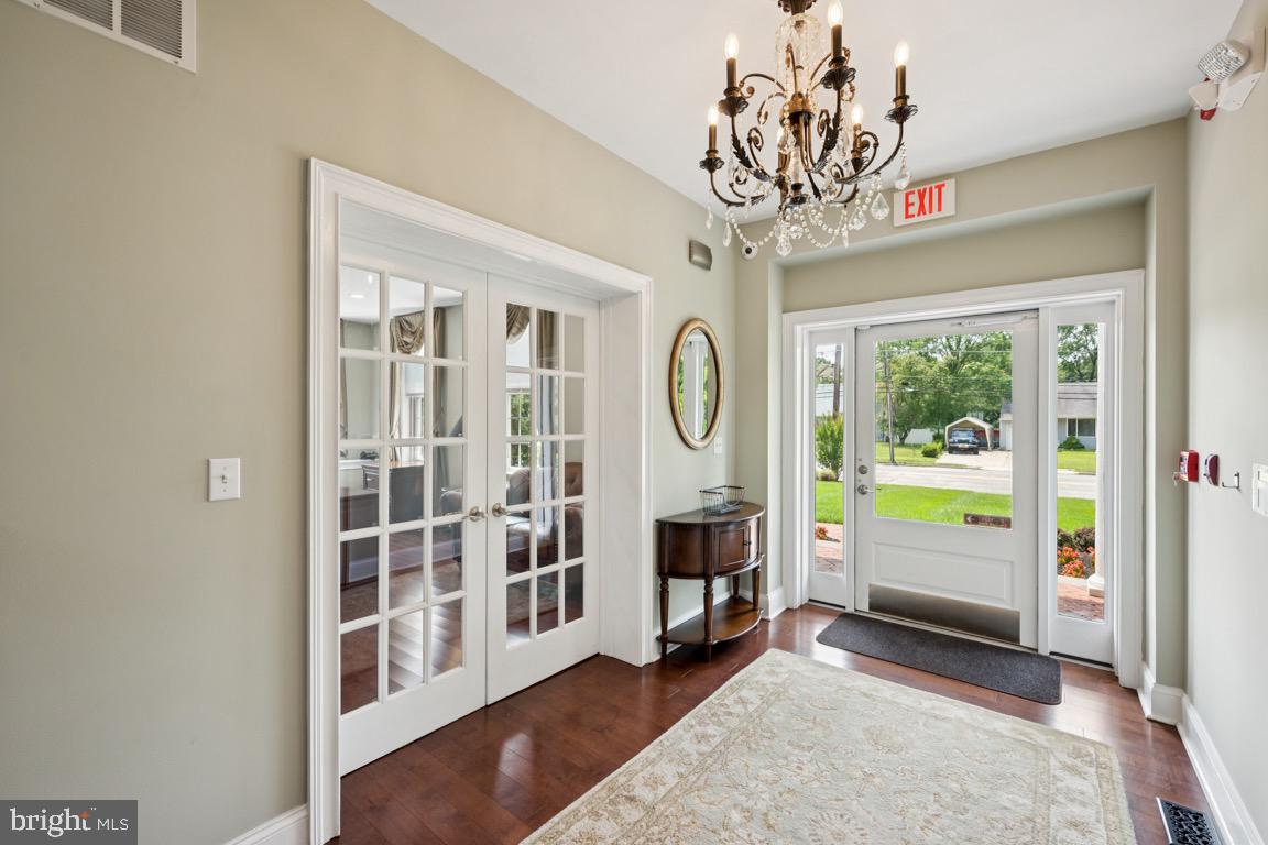 1526 Haddonfield-Berlin Road Cherry Hill, NJ 08003 - Photo 3 of 24 a view of an entryway with wooden floor and a chandelier