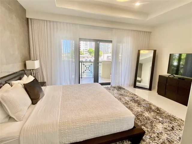 a bedroom with a large bed and wooden floor