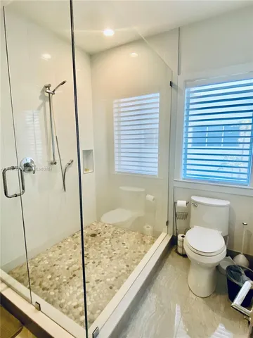 a bathroom with a granite countertop sink and a toilet