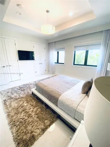 a bedroom with a bed and a view of kitchen