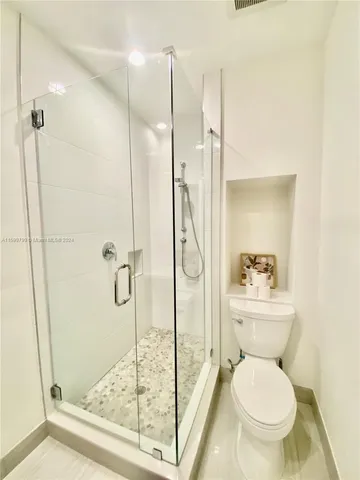 a bathroom with a granite countertop toilet sink and shower