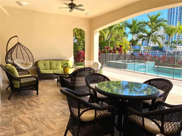 a dining room with furniture and a floor to ceiling window