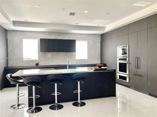 a kitchen with a sink a counter top space appliances and windows