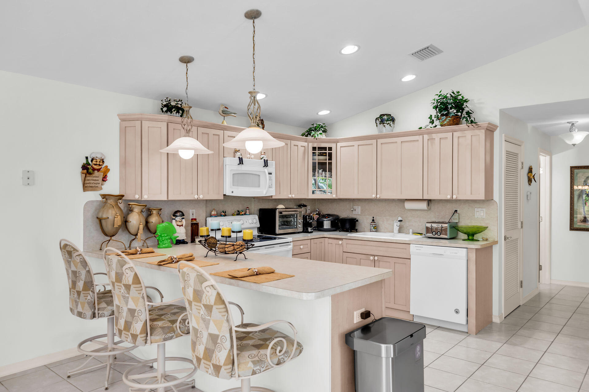 130 9th Street Key Colony Beach, FL 33051 - Photo 10 of 36 a kitchen with a dining table chairs and white cabinets