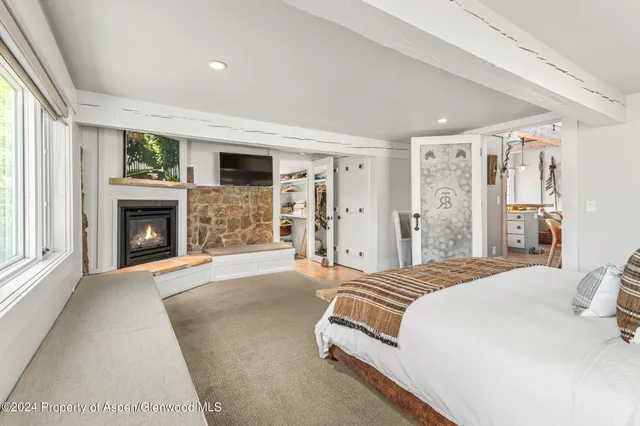a spacious bedroom with a bed and a fireplace