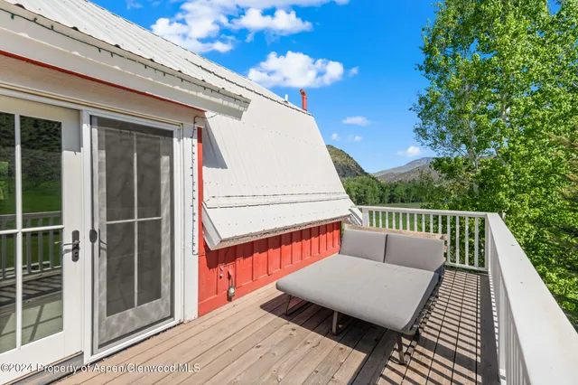 a roof deck with wooden floor and fence