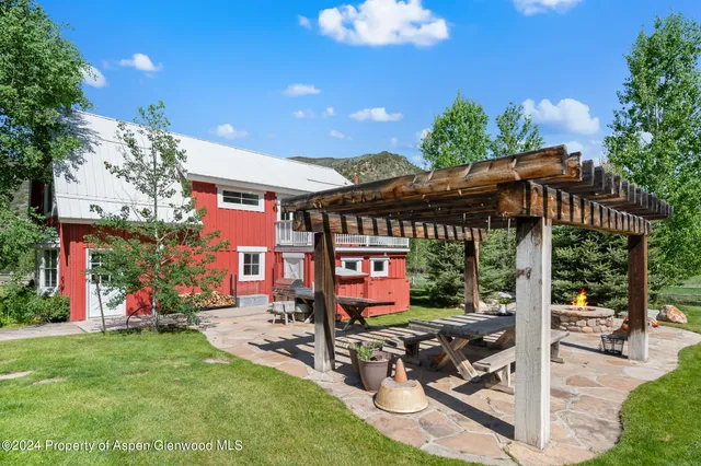 a view of a patio with a table and chairs under an umbrella