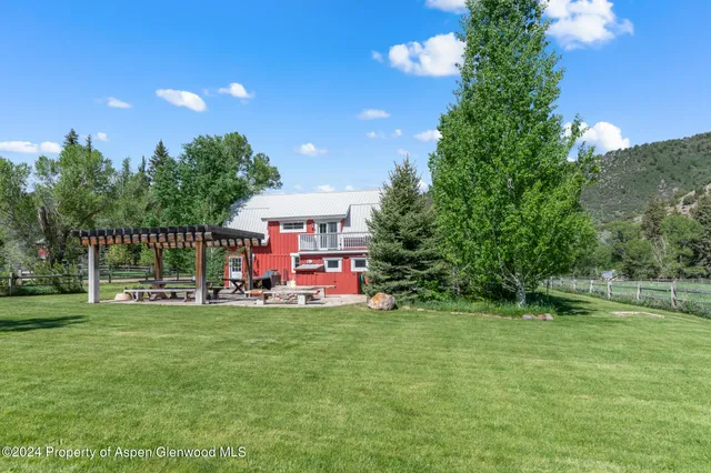 a view of a house with a yard and sitting area