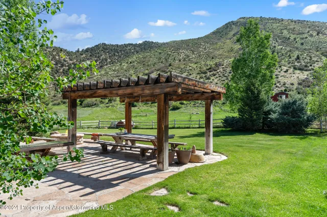 a view of a deck with a table chairs and a large tree