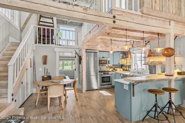 a view of a kitchen with furniture and wooden floor