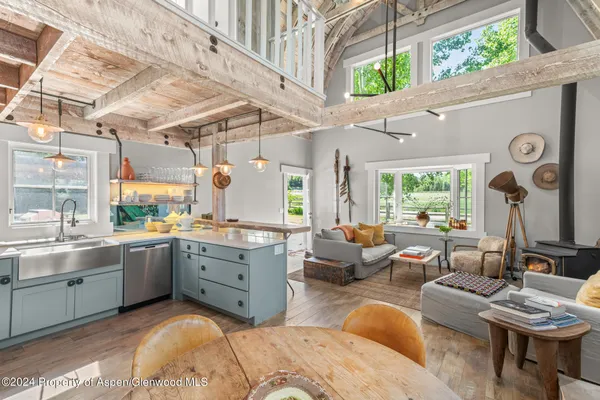 a large living room with granite countertop furniture a chandelier a large window and potted plants