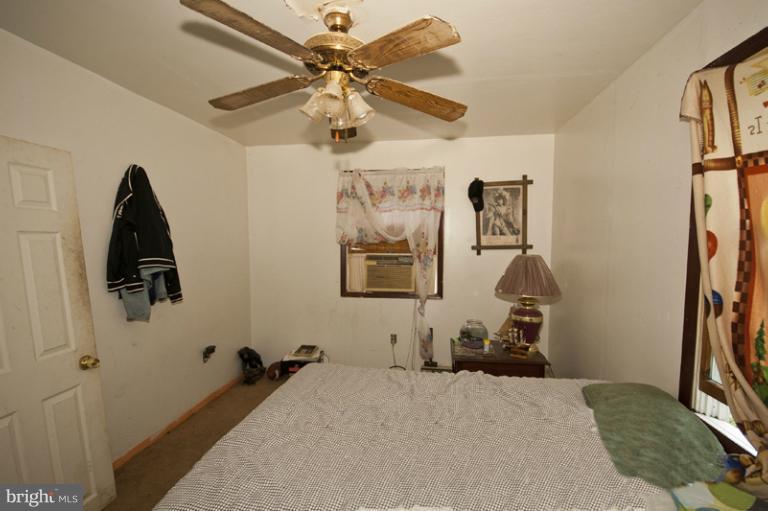 2842 Lodge Farm Road Sparrows Point, MD 21219 - Photo 2 of 8 a bedroom with a bed and a chandelier