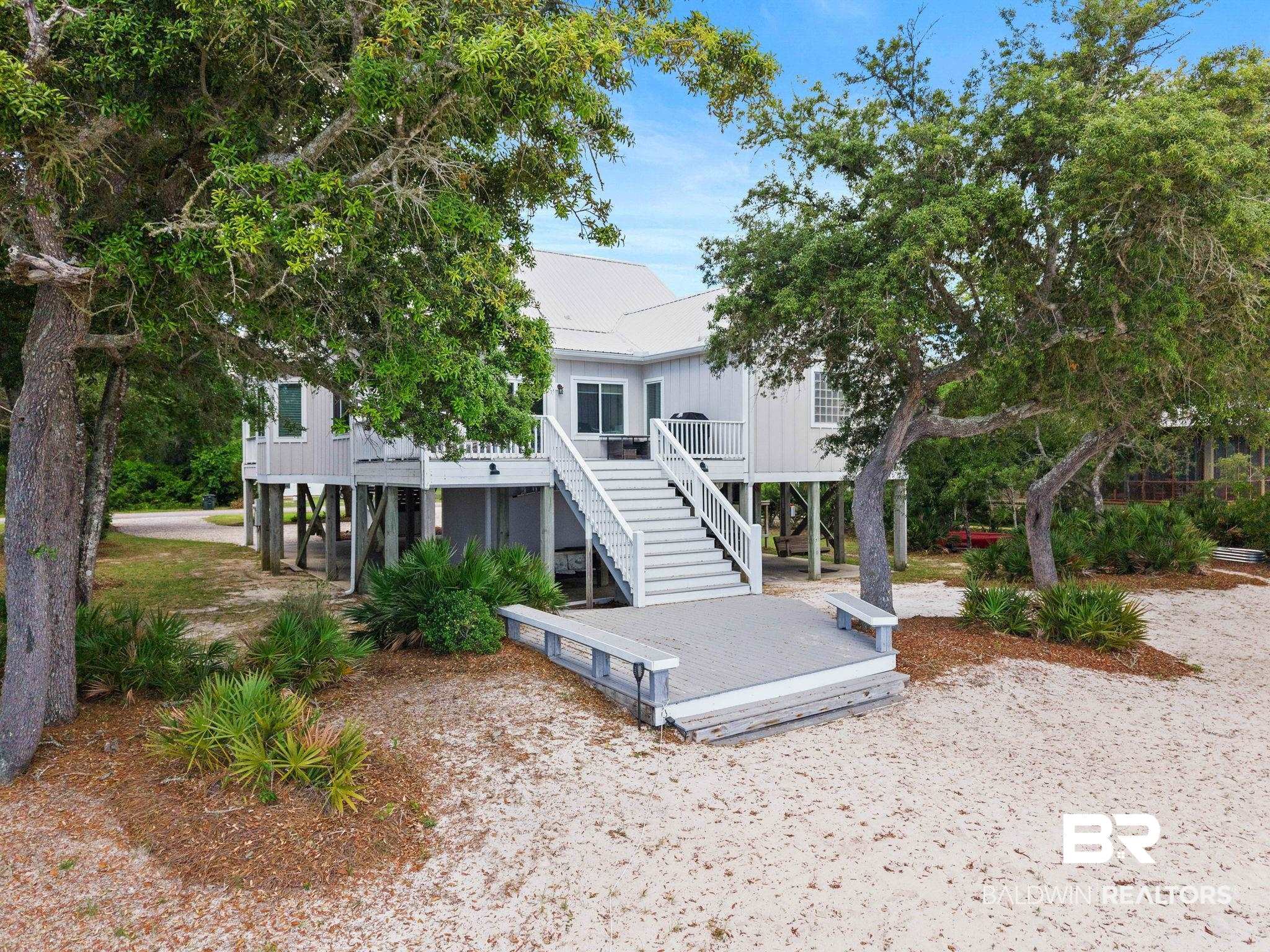 6802 Shore Drive Elberta, AL 36530 - Photo 7 of 34 Elevated coastal residence featuring a light gray exterior, metal roof, and an expansive outdoor deck