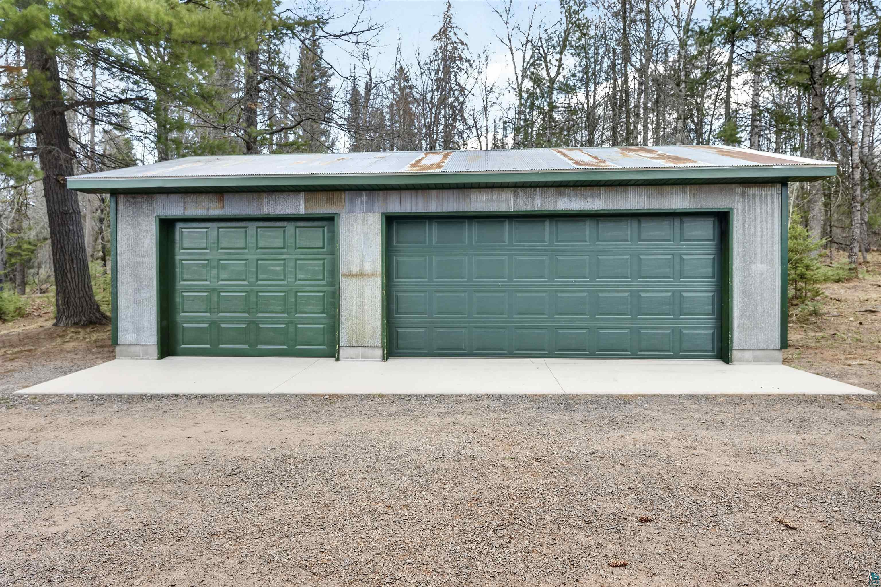 13885 Park Road Brule, WI 54820 - Photo 35 of 41 Two-stall garage featuring green panel garage doors and a concrete apron