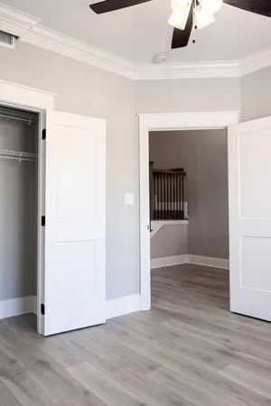 a view of a livingroom with wooden floor and a ceiling fan