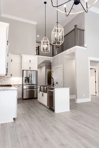 a large kitchen with cabinets wooden floor and stainless steel appliances