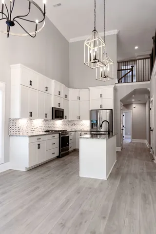 a large kitchen with kitchen island a stove a sink a center island and cabinets