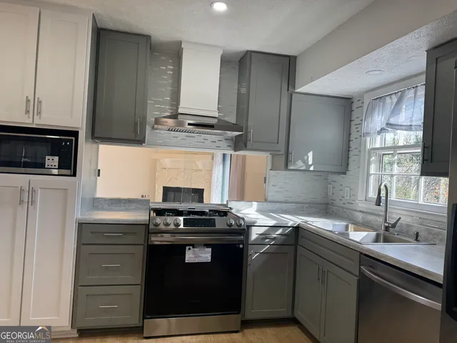 a kitchen with stainless steel appliances granite countertop a stove and a microwave